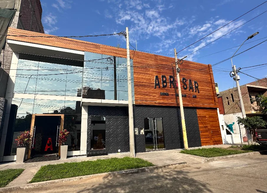 Fachada de ABRASAR: frente de madera con el letrero ABRASAR, vidrio y la A roja en la entrada